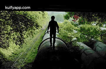a silhouette of a man standing on a train track .