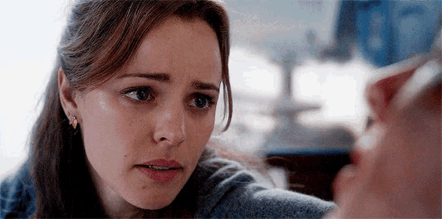 a woman with a sad look on her face is looking at another woman .