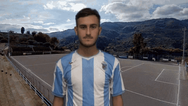 a man wearing a blue and white striped shirt with the word lazio on the front