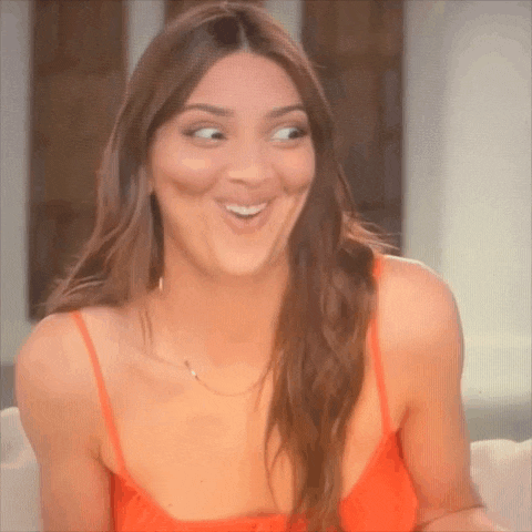a woman in a red dress is making a funny face .