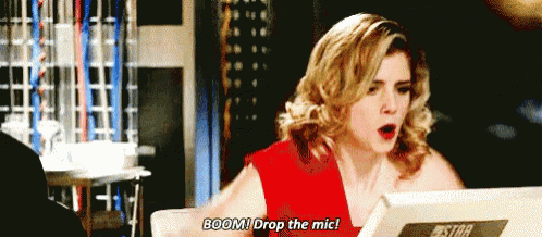 a woman in a red dress is sitting in front of a computer and says boom drop the mic