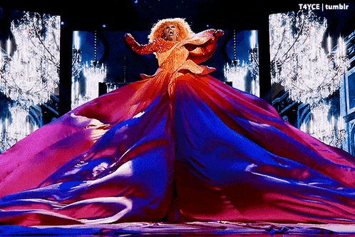 a woman in a very long red and blue dress is on a stage