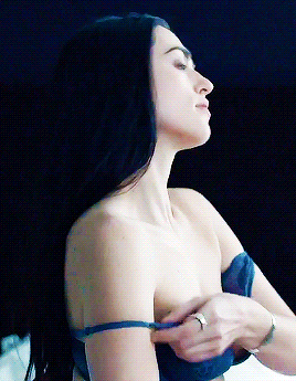 a woman in a blue bra is taking off her bra