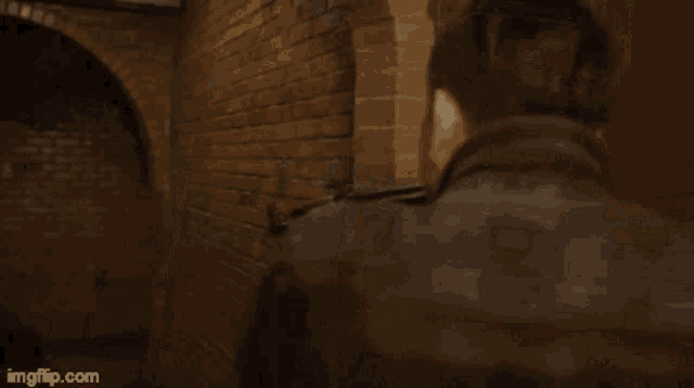 a man in a mask is standing in front of a brick wall