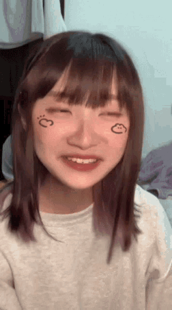 a girl with a heart drawn on her face is smiling