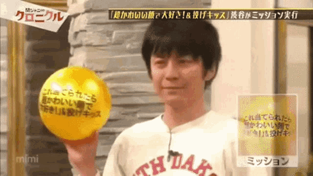 a man in a white shirt holds a yellow balloon in his hand