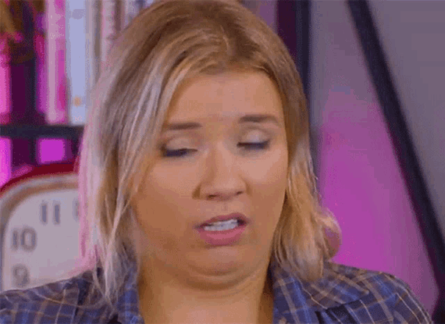a woman is making a funny face in front of a clock that says 10