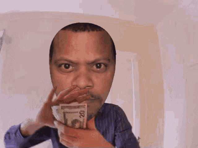 a man with a mustache is holding a bunch of money in front of his face