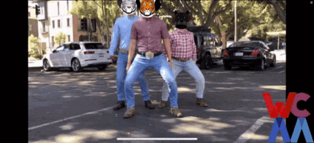 a group of men are dancing in a parking lot with a wc logo on the bottom