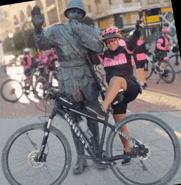 a woman posing with a statue and a bike that says ghost on it
