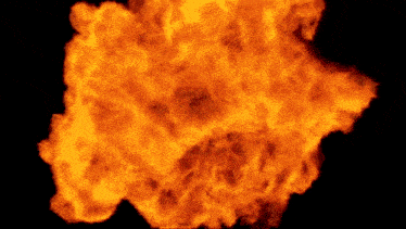 a large explosion of fire on a black background in slow motion