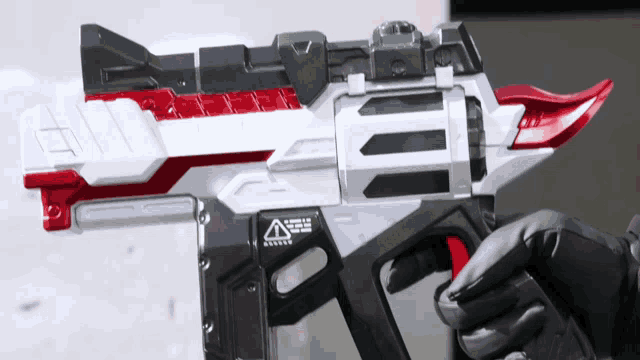 a person is holding a toy gun with a warning sign on the side