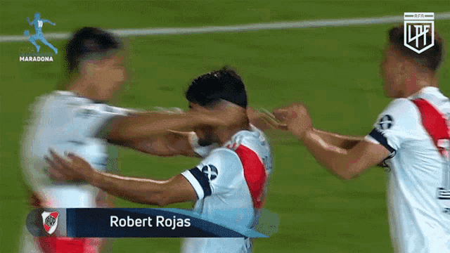 a soccer player named robert rojas is hugging another player on the field