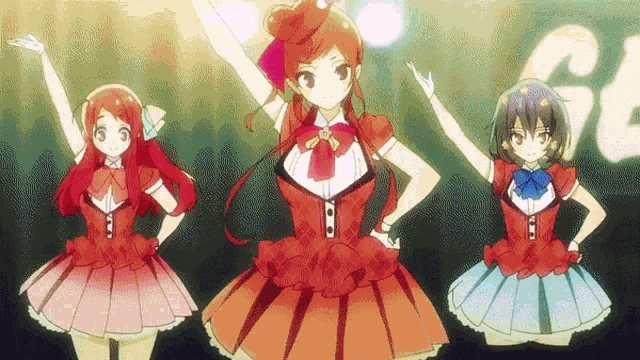 three anime girls are dancing on a stage with their arms in the air .