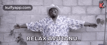 a man in a cowboy hat is standing in front of a brick wall with his arms outstretched and says relax avutanu