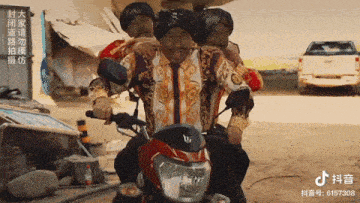 a group of men are riding a red motorcycle with the number 6157308 on the bottom of the screen