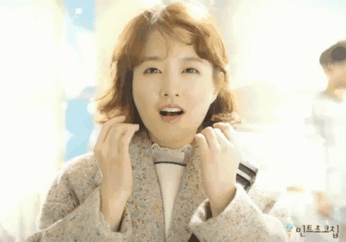 a close up of a woman 's face with korean writing on the bottom left corner