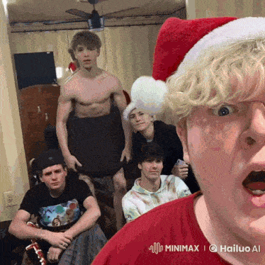 a man wearing a santa hat is surrounded by a group of young men