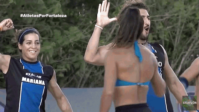 a woman wearing a mariana shirt is giving a high five to a man