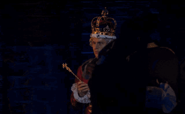 a man in a crown holds a scepter in his hand