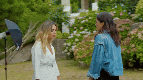 a woman in a white dress and a woman in a blue jacket are standing next to each other