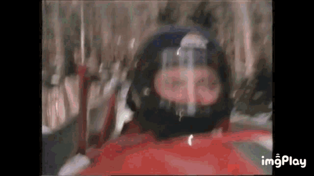 a man is wearing a helmet while riding a sled down a hill .