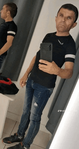 a man is taking a selfie in a dressing room with his phone