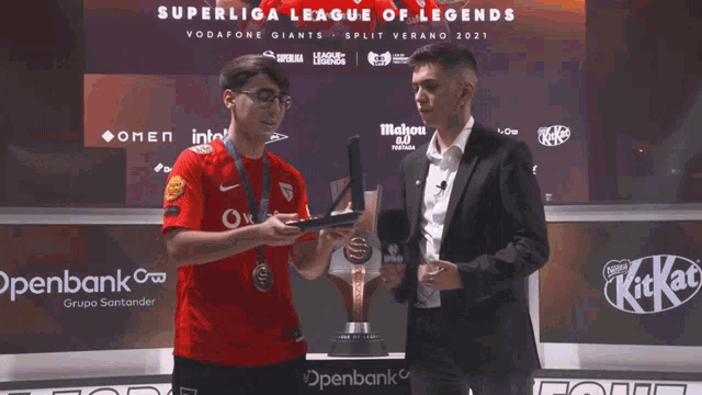 two men are standing in front of a superliga league of legends sign