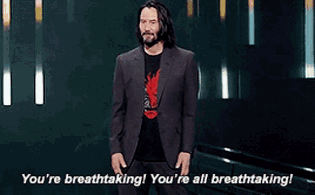 a man in a suit stands in front of a sign that says you 're breathtaking