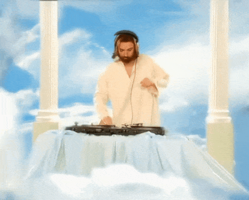 a man in a white robe is standing on a table with a microphone in his hand
