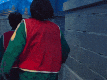 a man in a red shirt with the letter s on it is carrying another man