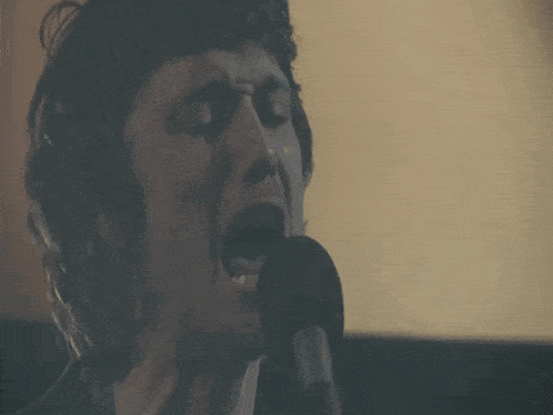 a woman is singing into a microphone with her mouth open