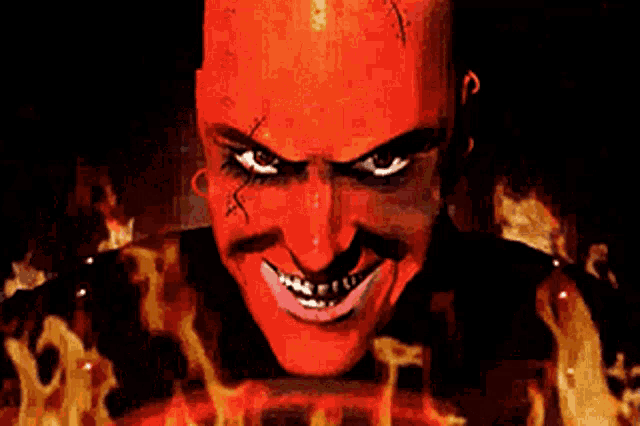 a close up of a devil 's face with flames behind it