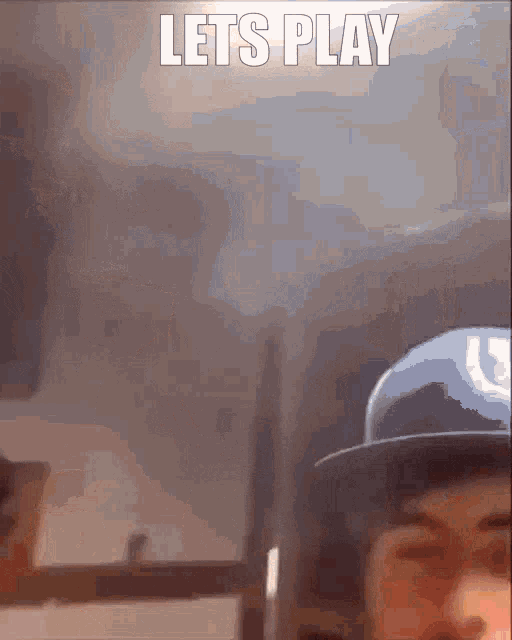 a man wearing a hat says let 's play in front of him