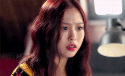 a close up of a woman 's face with red hair .