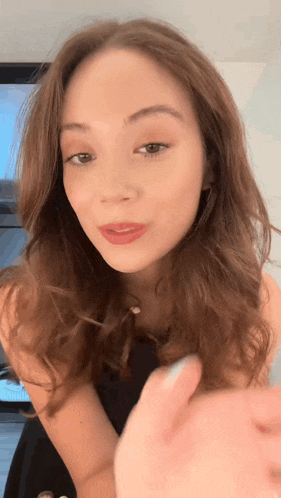 a close up of a woman 's face with a thumbs up