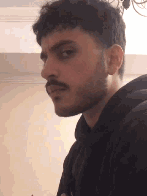 a man with a beard is wearing a black sweatshirt