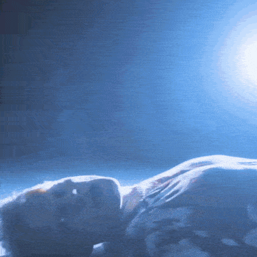 a person laying on their back with their eyes closed in a dark room