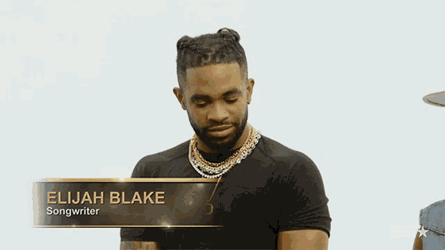 a man with a name tag that says elijah blake songwriter on it