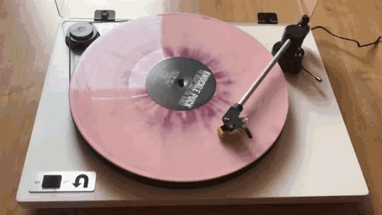 a record player with a pink record on it