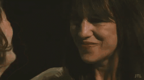 two women are looking at each other and smiling .