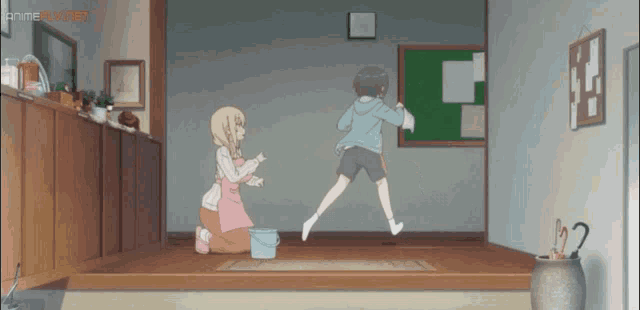 a girl is kneeling down next to a boy who is jumping