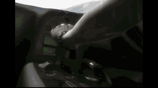 a blurred image of a person 's hand on a steering wheel in a car
