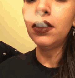 a close up of a woman smoking a cigarette .