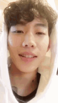 a close up of a man 's face with a white hoodie on