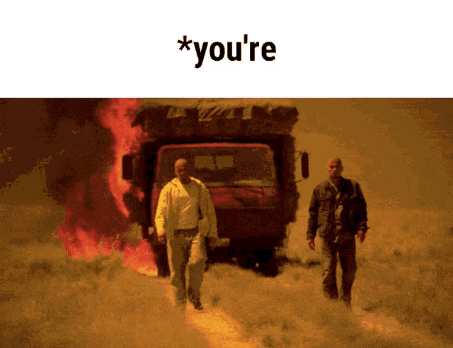 two men walking in front of a truck that is on fire with the words * you 're below