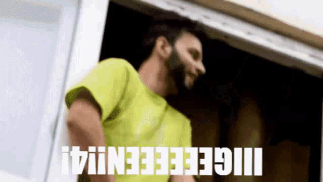 a man with a beard is standing in front of a window with the words ii geeeeeniii written on it .