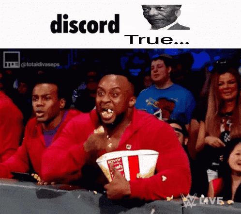 a man in a red jacket is holding a bucket of popcorn in front of a crowd