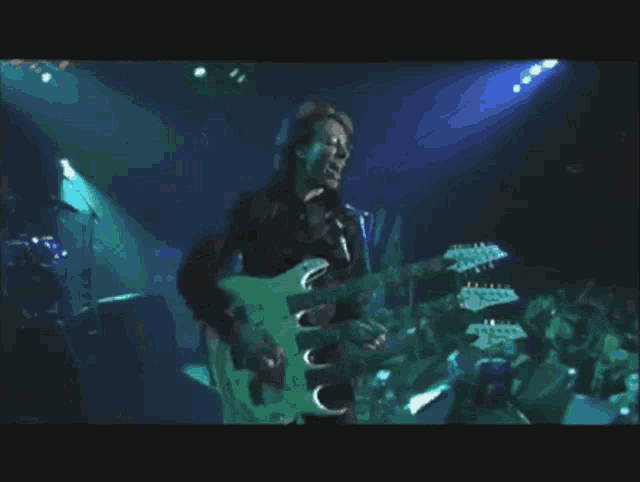 a man is playing a guitar with three necks on it
