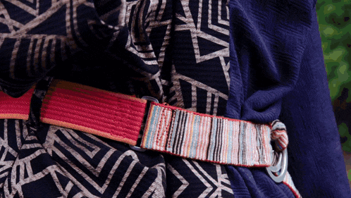 a person wearing a blue shirt with a striped belt